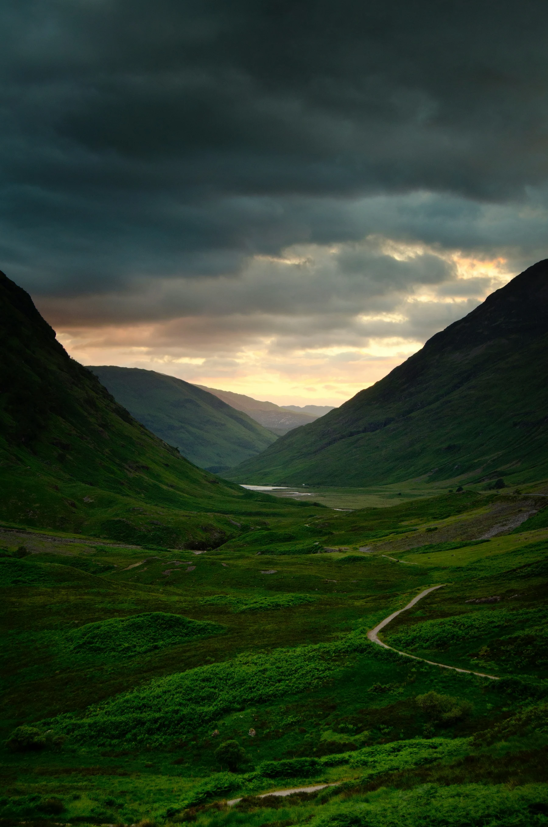 Green mountains framing a valley and a distant open horizon